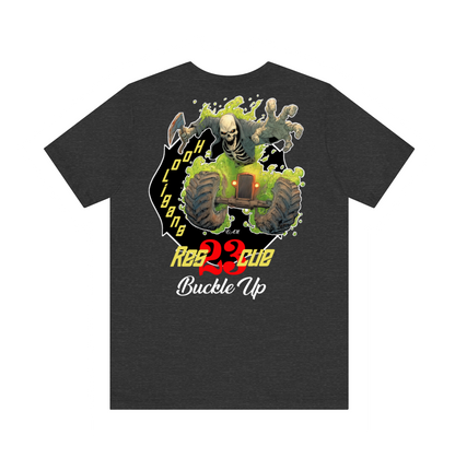 A dark heather gray t-shirt featuring a large graphic print on the front. The graphic depicts a skeleton riding a green buggy with a skull in its mouth, set against a black background with yellow and red text that reads 'REBELLION' and 'Buckle Up'.